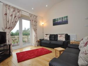 a living room with a couch and a large window at 2 Bed in Blakeney 54766 in Awre