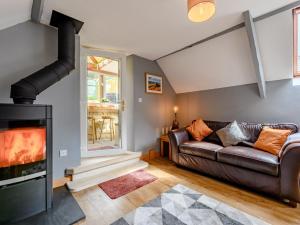 a living room with a leather couch and a fireplace at 2 Bed in Rothbury 83597 in Rothbury