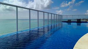 a swimming pool with a view of the ocean at Apartamentos no RN Studio Premium in Maceió