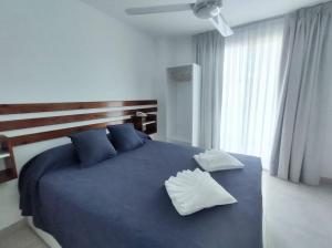 Un dormitorio con una gran cama azul con almohadas azules en Catalina Hotel en Colón