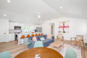 un salon avec un canapé bleu et une cuisine dans l'établissement 2 Kings Hot Tub Modern Cottage Hill Country, à Blanco