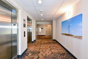 un couloir dans un bureau avec une peinture d'un moulin à vent dans l'établissement Hampton Inn & Suites Pittsburg, à Pittsburg