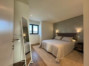 a bedroom with a large bed and a mirror at Paradis bleu in Marinhas +20 photos