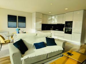 a living room with a white couch with blue pillows at Paradis bleu in Marinhas