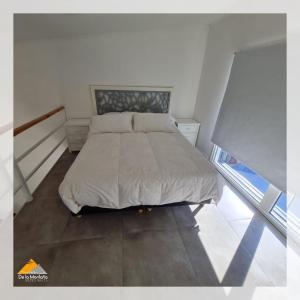 a bedroom with a bed in a white room at De La Montaña - Loft in Esquel