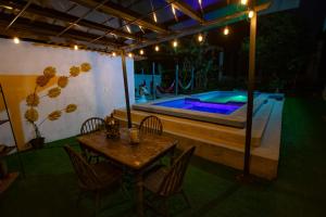 a patio with a table and a swimming pool at night at Amancay House in San Cristobal