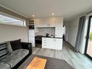 a living room with a couch and a kitchen at Hank's Hut in Lake Tekapo
