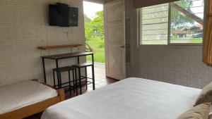 Schlafzimmer mit einem Bett, einem TV und einem Fenster in der Unterkunft Finca Hotel Santana in Montenegro
