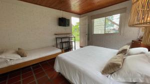 1 dormitorio con 2 camas y ventana en Finca Hotel Santana en Montenegro