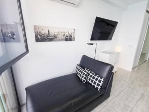 un sofá de cuero negro en una sala de estar con TV en Mirador 20 Sea View By Pride Holiday Rentals, en San Agustín