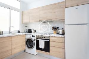 a kitchen with a washing machine and a refrigerator at The Happy Place Santa Cruz, by Nivariahost in Santa Cruz de Tenerife
