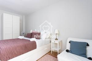 1 dormitorio blanco con 1 cama y 1 silla en The Happy Place Santa Cruz, by Nivariahost, en Santa Cruz de Tenerife