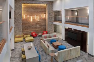 a living room with a couch and chairs and a tv at Hilton Garden Inn Los Angeles Marina Del Rey in Los Angeles