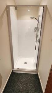 une salle de bain avec une douche avec une porte vitrée dans l'établissement Avocado Orchard Retreat!, à Katikati 18 autres photos