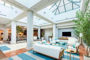 a living room with white furniture and a large ceiling at DoubleTree by Hilton San Juan in San Juan