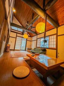 草津町にある源泉掛け流し付き貸切別荘-Authentic private home with Private Kusatsu Onsen - THE HIDEOUT VILLA KUSATSU-のリビングルーム(テーブル、ソファ付)