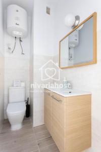 uma casa de banho com um WC, um lavatório e um espelho. em The Happy Place Santa Cruz, by Nivariahost em Santa Cruz de Tenerife