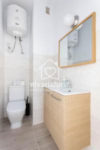 a bathroom with a toilet and a sink and a mirror at The Happy Place Santa Cruz, by Nivariahost in Santa Cruz de Tenerife