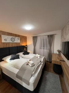 a bedroom with a large bed and a flat screen tv at Ferienwohnung E in Soltau