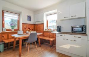 a kitchen with white cabinets and a wooden table at Ferienwohnung In Irschen in Irschen
