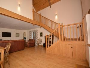 a living room with a wooden staircase and a couch at 3 Bed in Wells 55232 in Chewton Mendip