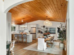 una cucina e una sala da pranzo con soffitto in legno di Lakeside Oasis a Kalkaska