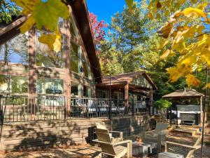 um alpendre de uma casa com cadeiras e um guarda-sol em Lakeside Oasis em Kalkaska