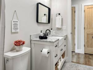 a white bathroom with a sink and a toilet at Lakeside Oasis in Kalkaska