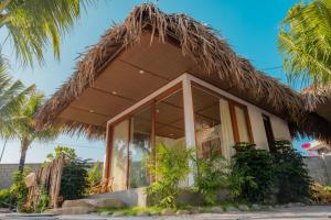 a resort with a thatched roof at OLIVE Camping in Lagi