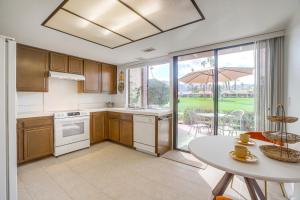 a kitchen with a table and a table and an umbrella at Stunning Palm Desert Condo with Golf Course Views! in Palm Desert