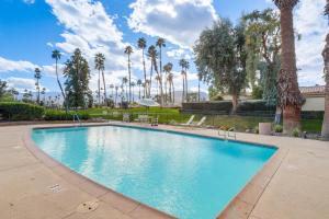 a swimming pool with palm trees in a park at Stunning Palm Desert Condo with Golf Course Views! in Palm Desert