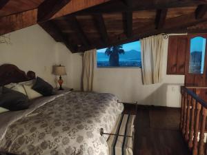 a bedroom with a bed and a window at Cabañas "Rancho La Mesa" in Pátzcuaro