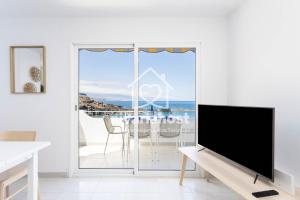 a living room with a tv and a view of the ocean at Ocean View El Pris, by Nivariahost in El Pris