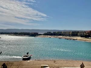 a boat in the water next to a beach at Y 140 wast golf heated private pool in Hurghada