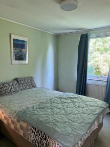 een slaapkamer met een bed en een raam bij Home Stays-Private Rooms in a Villa Near City for families/Individuals in Stockholm