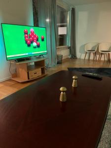 een woonkamer met een televisie en een tafel met ballen erop bij Home Stays-Private Rooms in a Villa Near City for families/Individuals in Stockholm