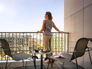 una donna sul balcone di un edificio di Novotel Paris Coeur d'Orly Airport a Orly