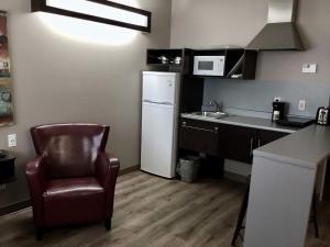 a kitchen with a chair and a white refrigerator at Villa Inn & Suites - SureStay Collection by Best Western in Hearst