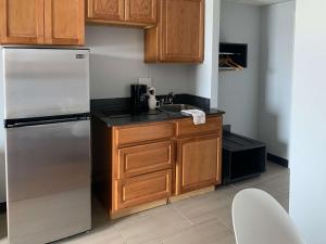 a kitchen with wooden cabinets and a stainless steel refrigerator at Studio 6-Lincoln, NE - Airport in Lincoln