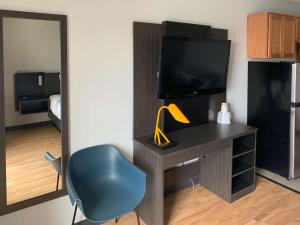 a room with a desk with a television and a chair at Studio 6-Lincoln, NE - Airport in Lincoln +16 photos