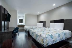 Habitación de hotel con 2 camas y TV de pantalla plana. en Motel 6 Houston, TX - I-10 West en Houston