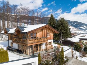 a log home with snow on the roof at Chalet Erlebnishaus I in Piesendorf
