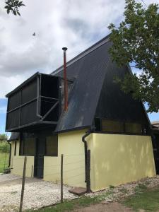 een huis met een zwart dak en een geel gebouw bij CASA 2 AGUAS MELINCUÉ in Melincué