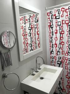een badkamer met een wastafel, een spiegel en een douchegordijn bij CASA 2 AGUAS MELINCUÉ in Melincué