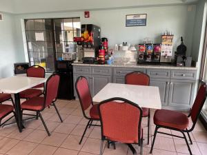 a restaurant with two tables and chairs and a counter at Nola Inn in Slidell