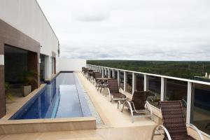 a balcony with chairs and a swimming pool on a building at Noroeste Atrium Platine Apartamento Completo in Brasilia