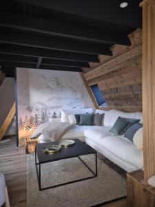 a living room with a white couch and a table at A l'orée des bois in Les Angles