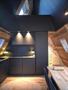 a kitchen with a wooden table and a wooden ceiling at A l'orée des bois in Les Angles