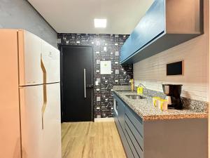 a kitchen with a refrigerator and a black door at Rover Centro in Sao Paulo