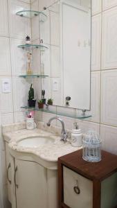 uma casa de banho com um lavatório e um espelho em Apartamento aconchegante no bairro Nova Petrópolis em São Bernardo do Campo